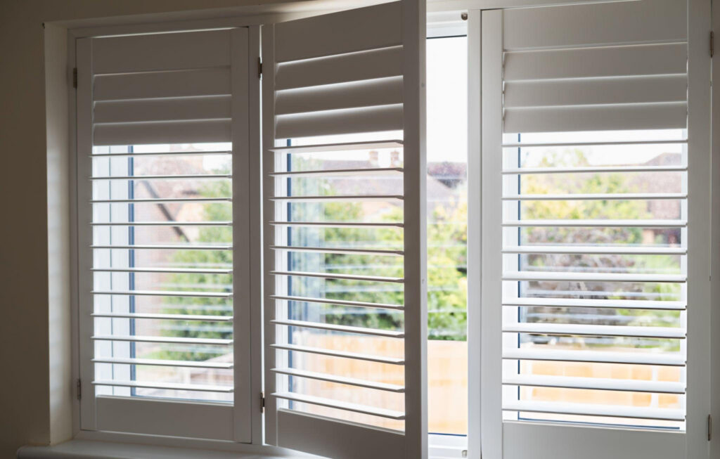 White plantation shutters installed above a dining table in a Bridgeland TX house