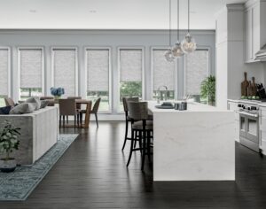 Grey roller shades installed across an open-plan kitchen, dining, and living area in Bridgeland, TX