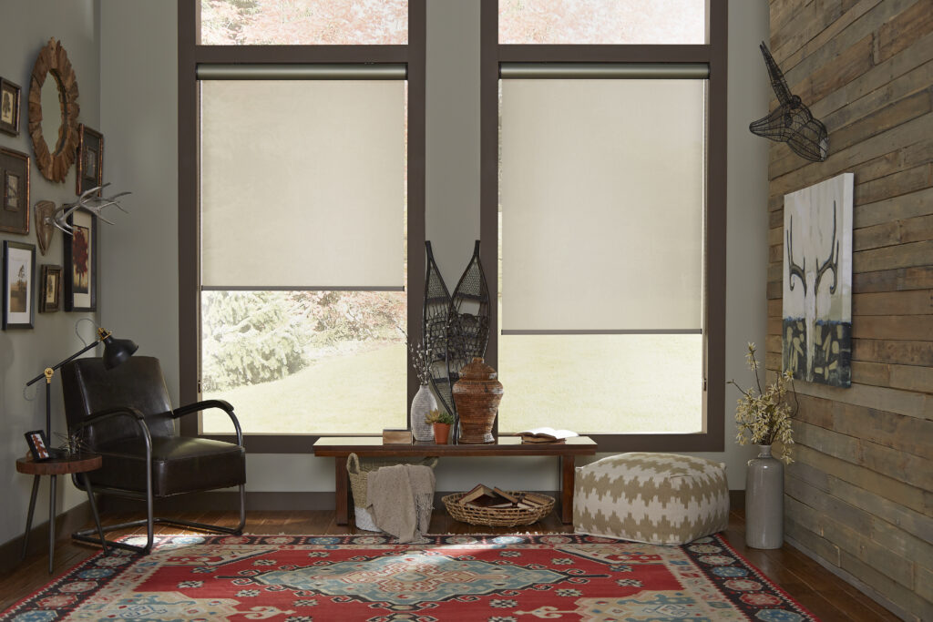 Cream roller shades on oversized windows in a rustic living room with leather chair in Bridgeland, TX