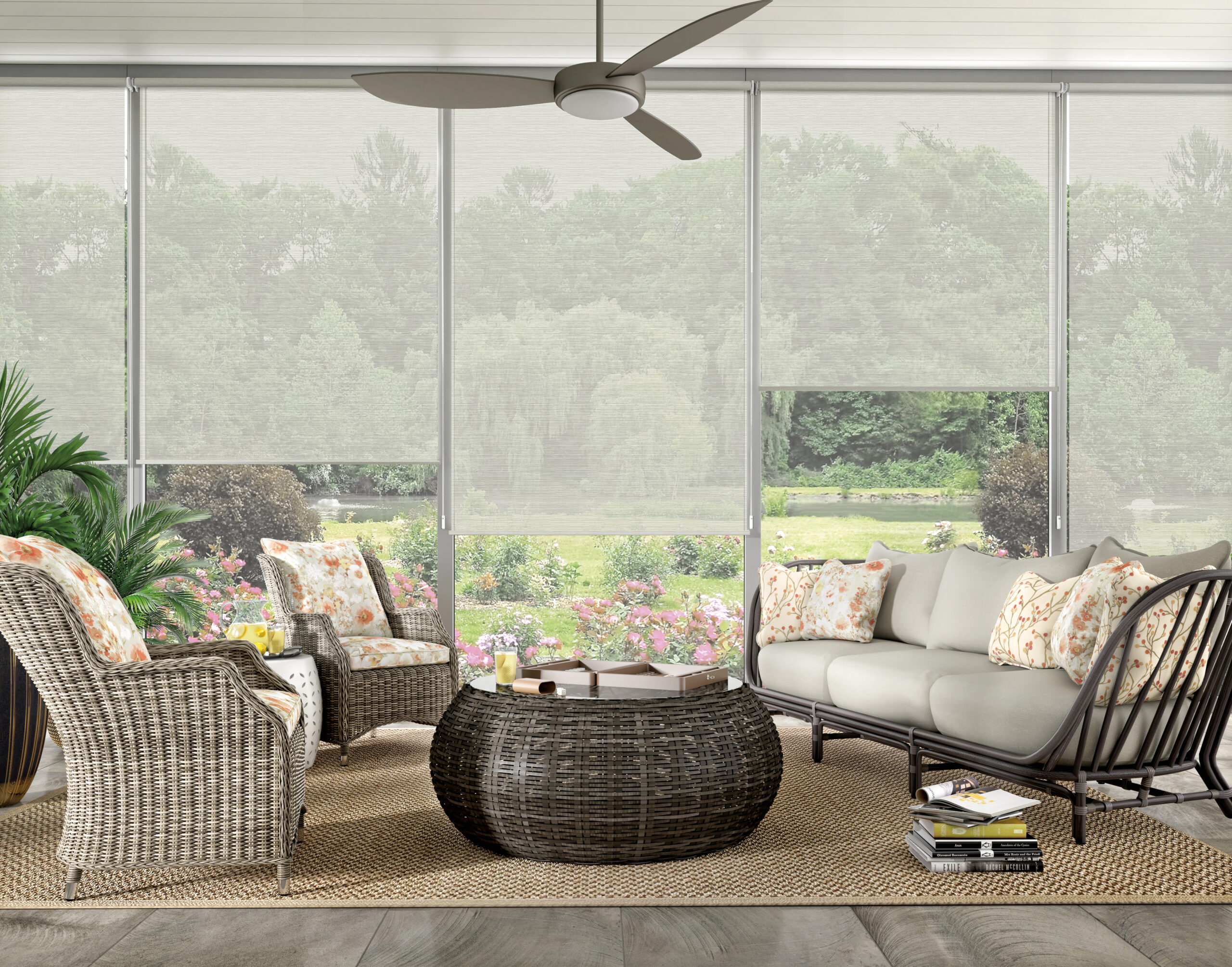 Sheer roller shades in a sunroom with wicker furniture and lush garden views in Bridgeland, TX